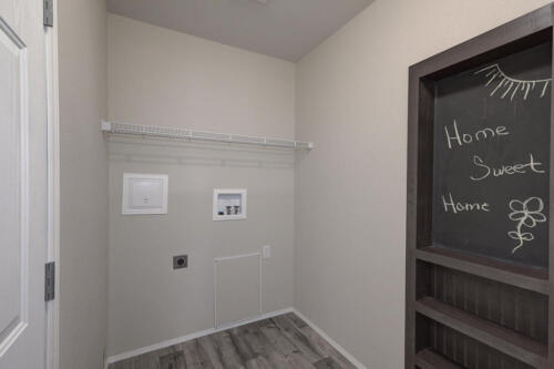 A walk in closet with a chalkboard on the wall.