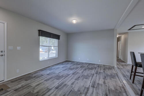 An empty living room with wood floors and a door.